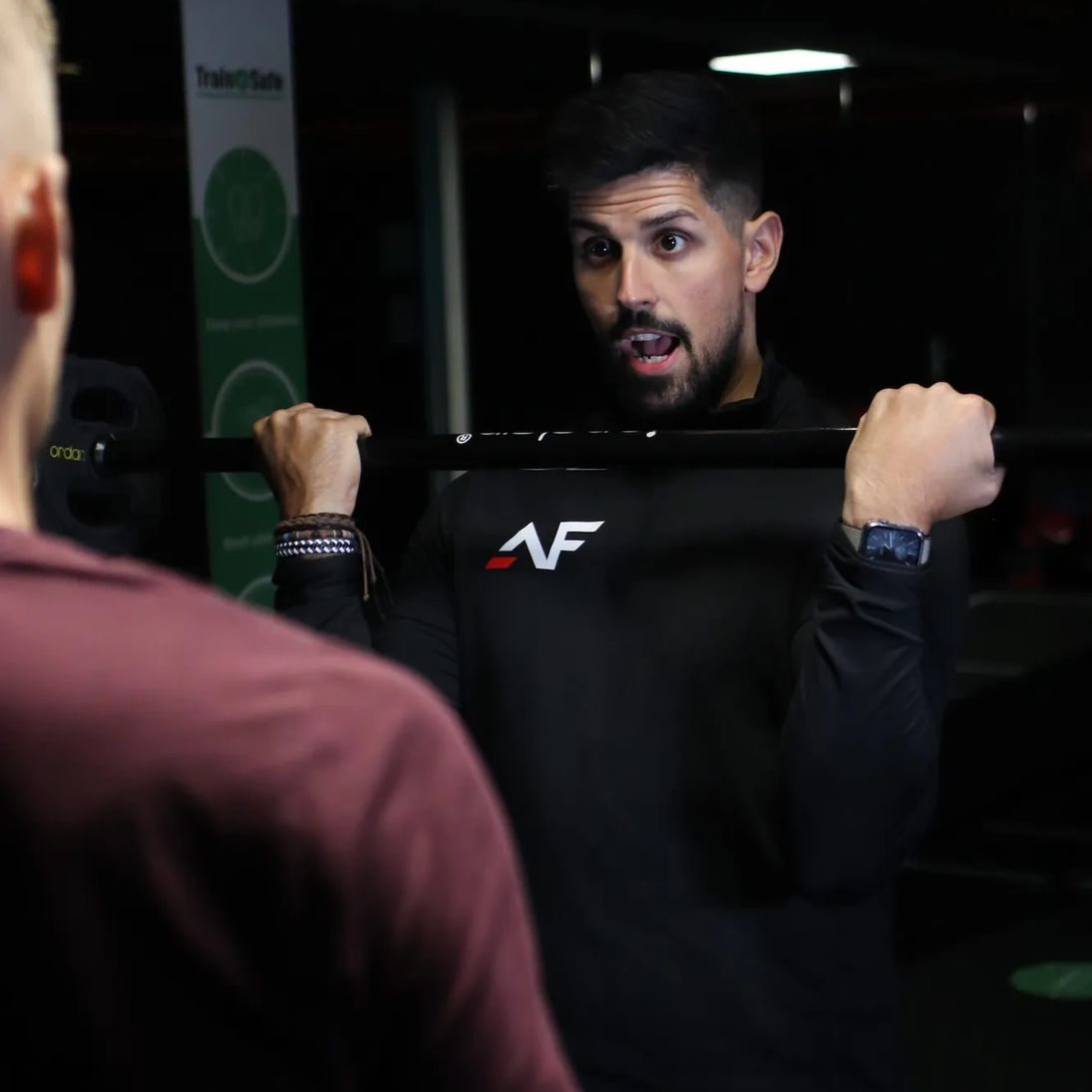 Andres coaching client through barbell squat technique at Andres Fitness PT session